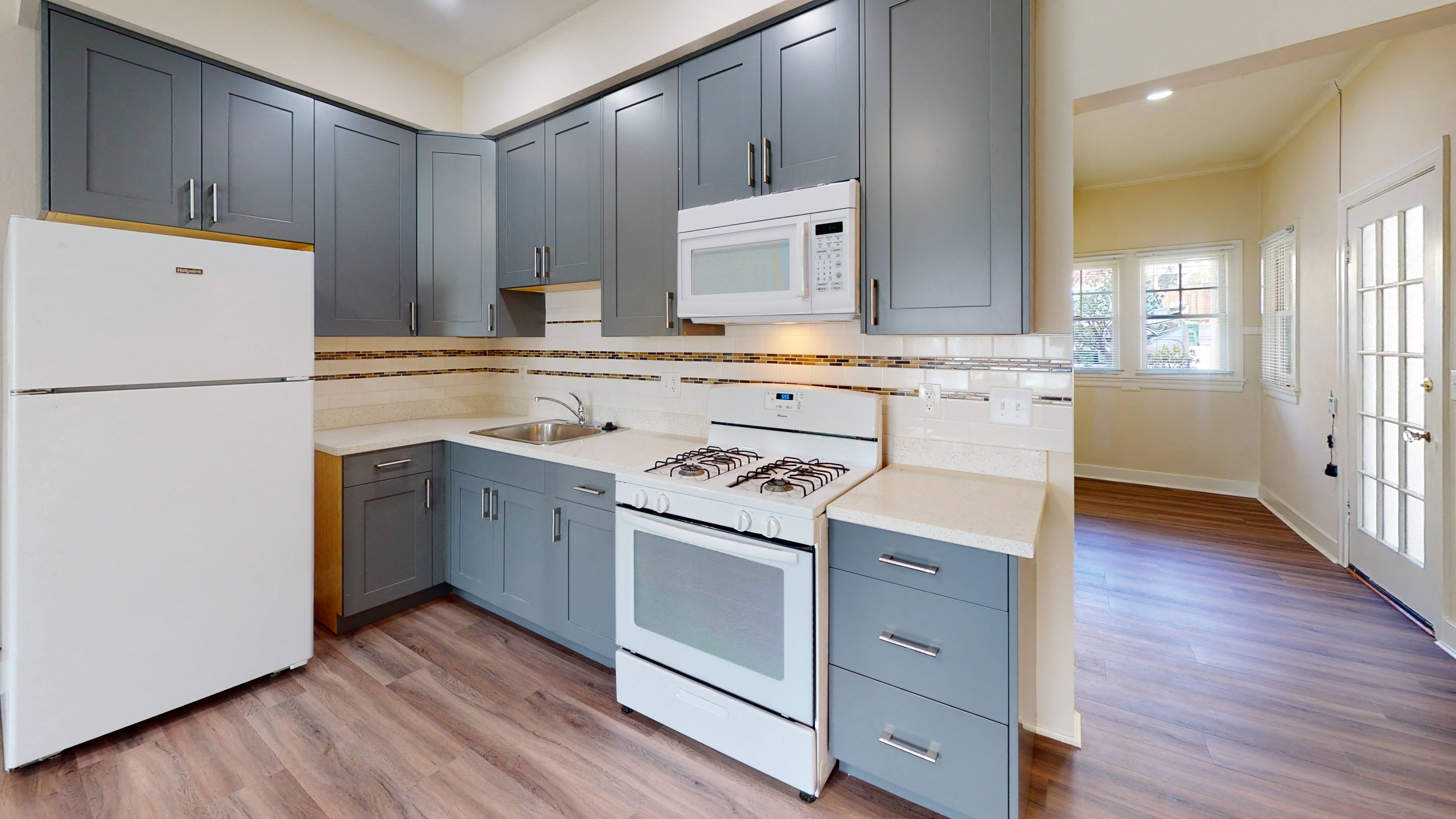 A kitchen with a white refrigerator and a white stove top oven.