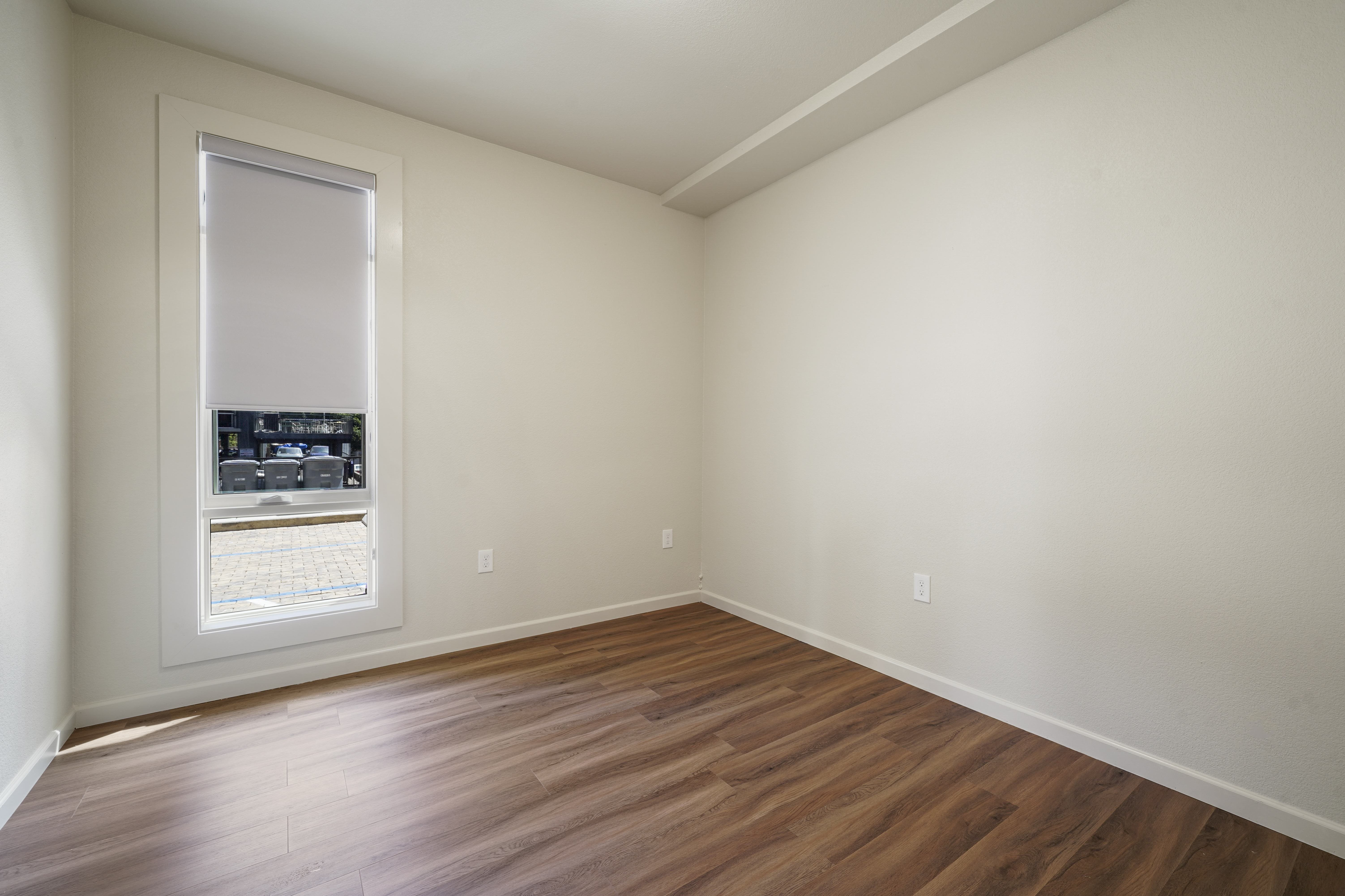 A room with a window and wooden floors.