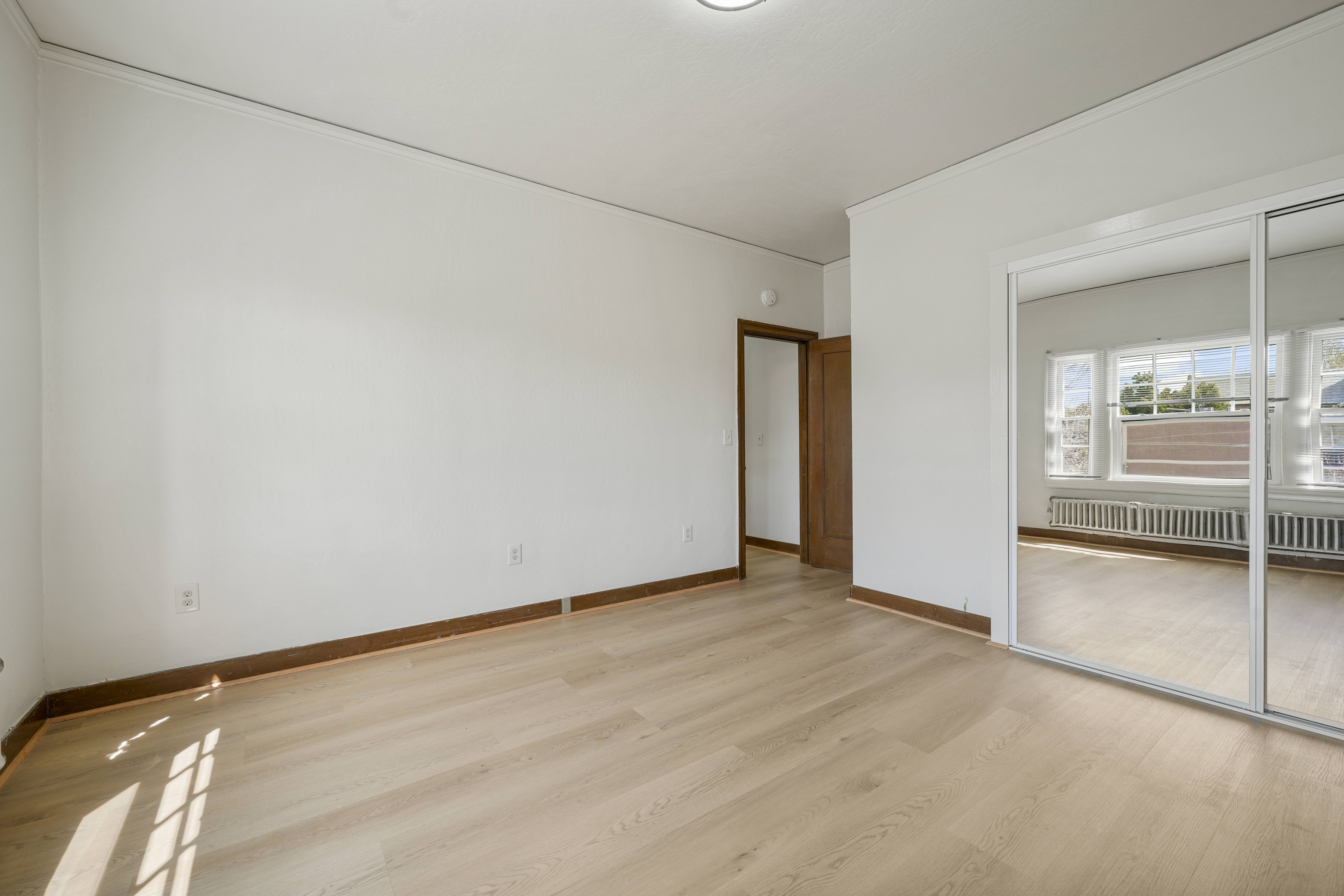 A room with a wooden floor and a sliding glass door.