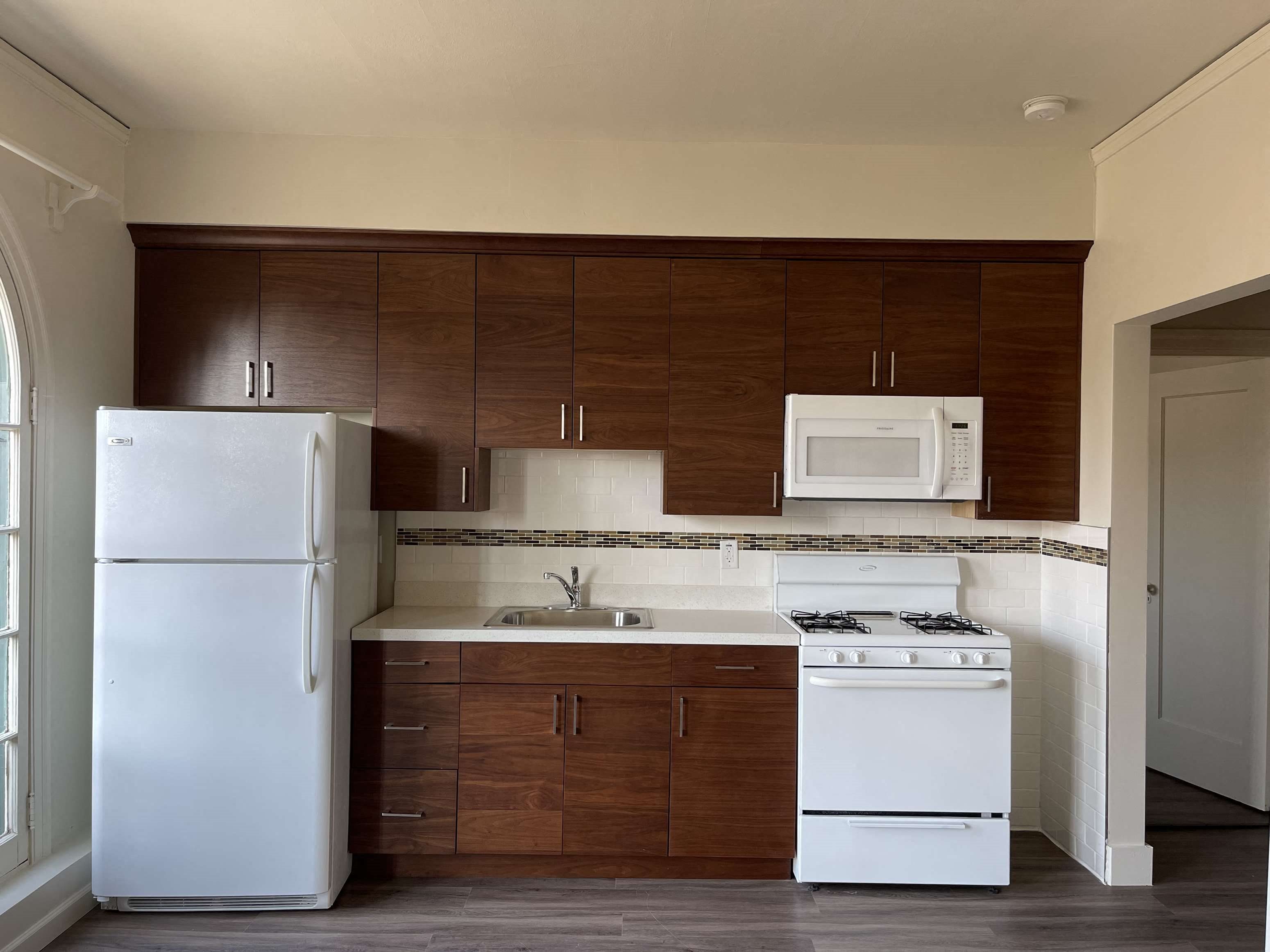 a small kitchen with white appliances and wooden cabinets