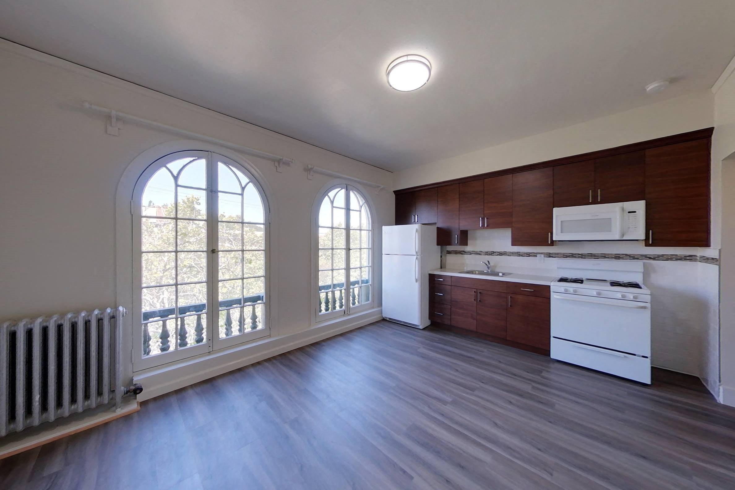 A kitchen with white appliances and wood cabinets.