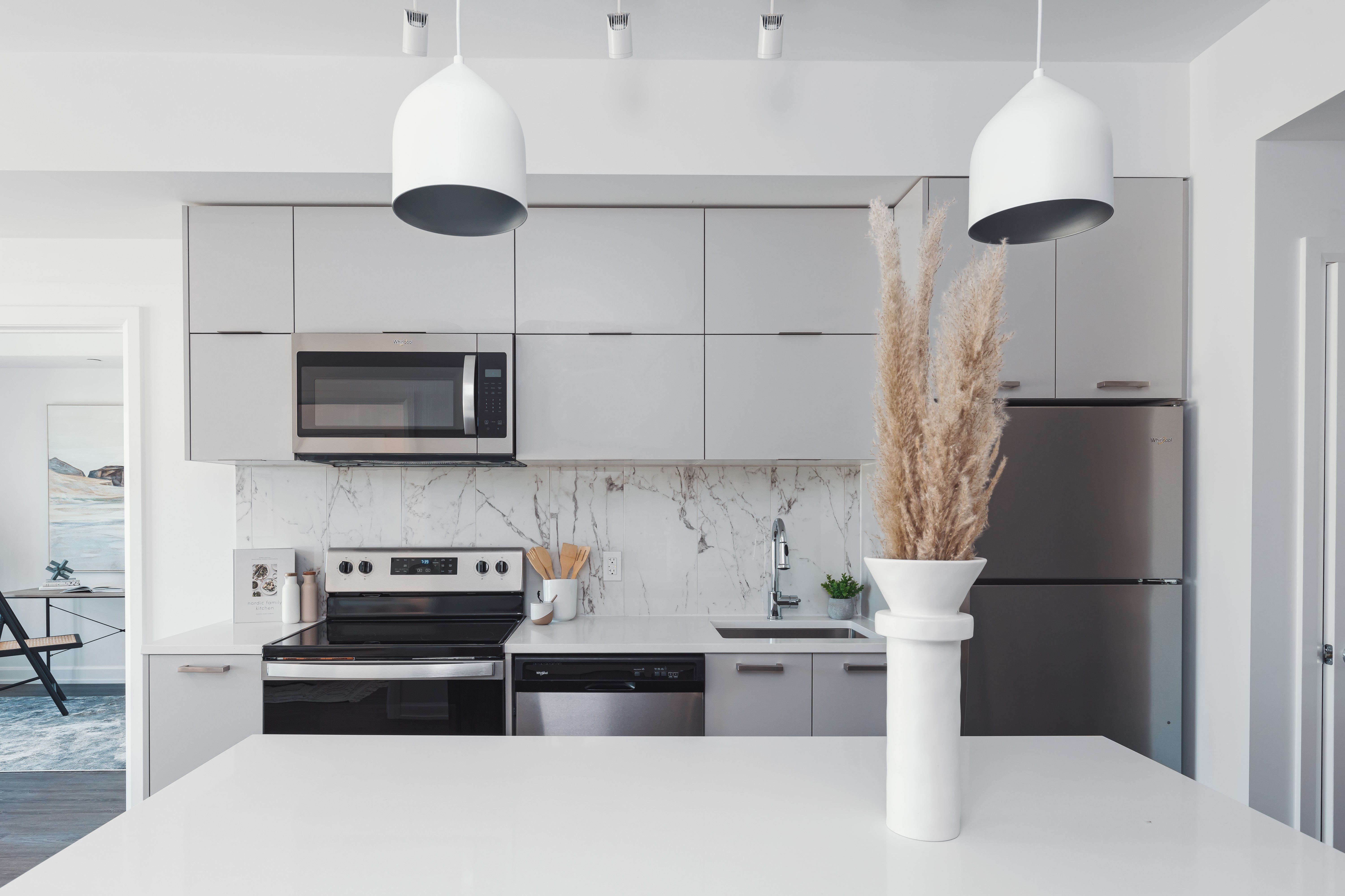 A modern kitchen with a white countertop and black appliances.