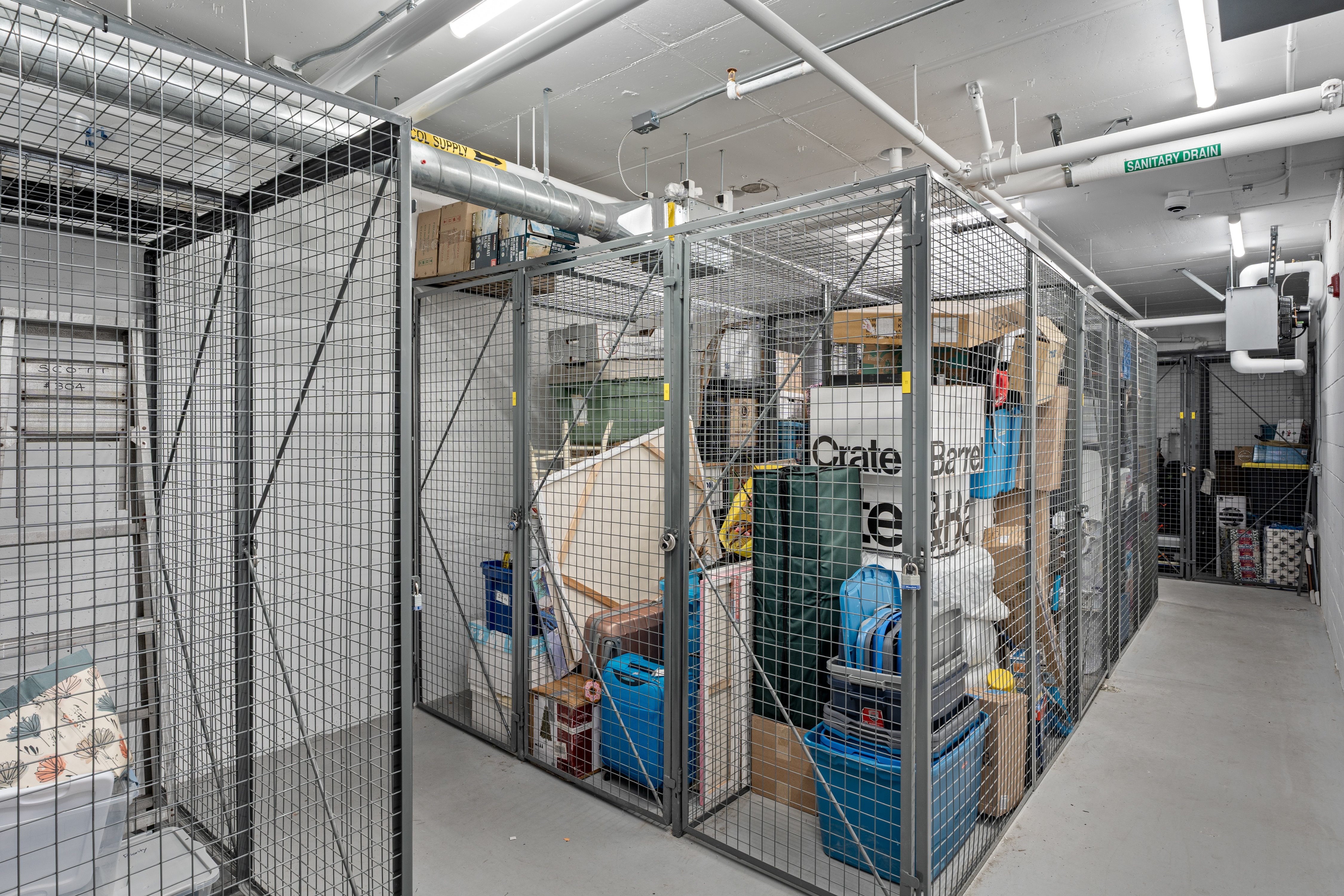 A storage room with wire mesh fencing and boxes on the shelves.