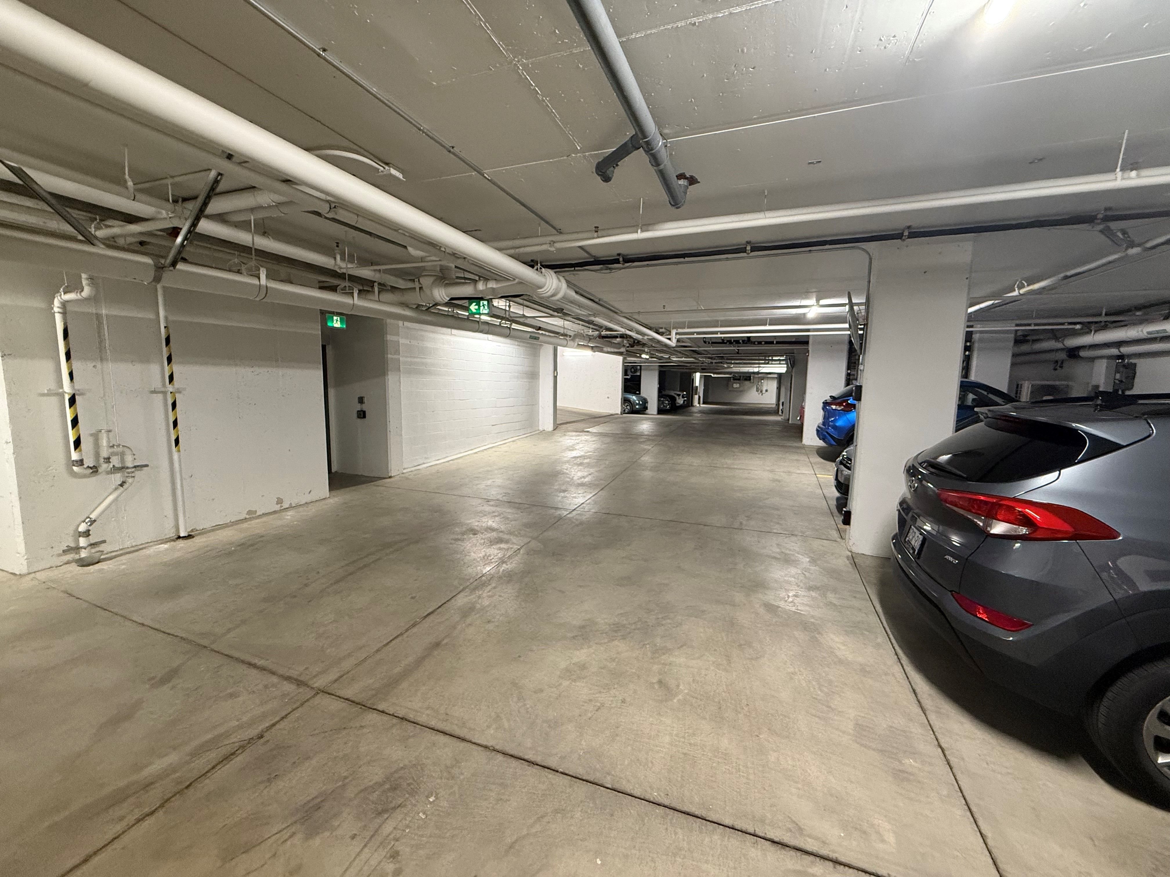 A parking garage with a car parked on the right side.