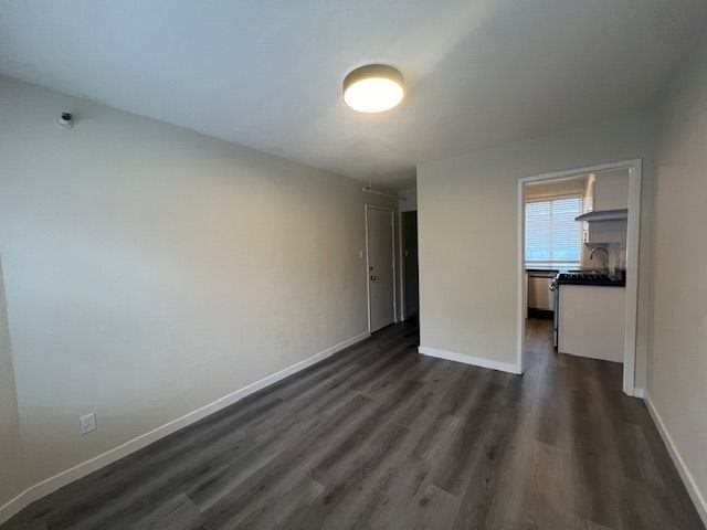 A room with a light on the ceiling and a doorway leading to another room.