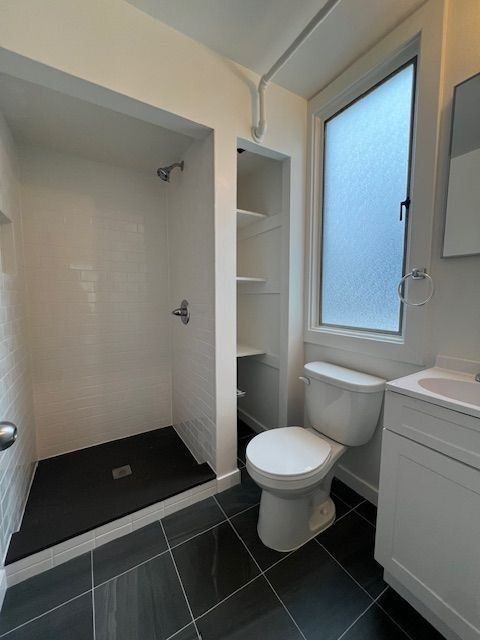 A white toilet sits next to a sink in a bathroom.
