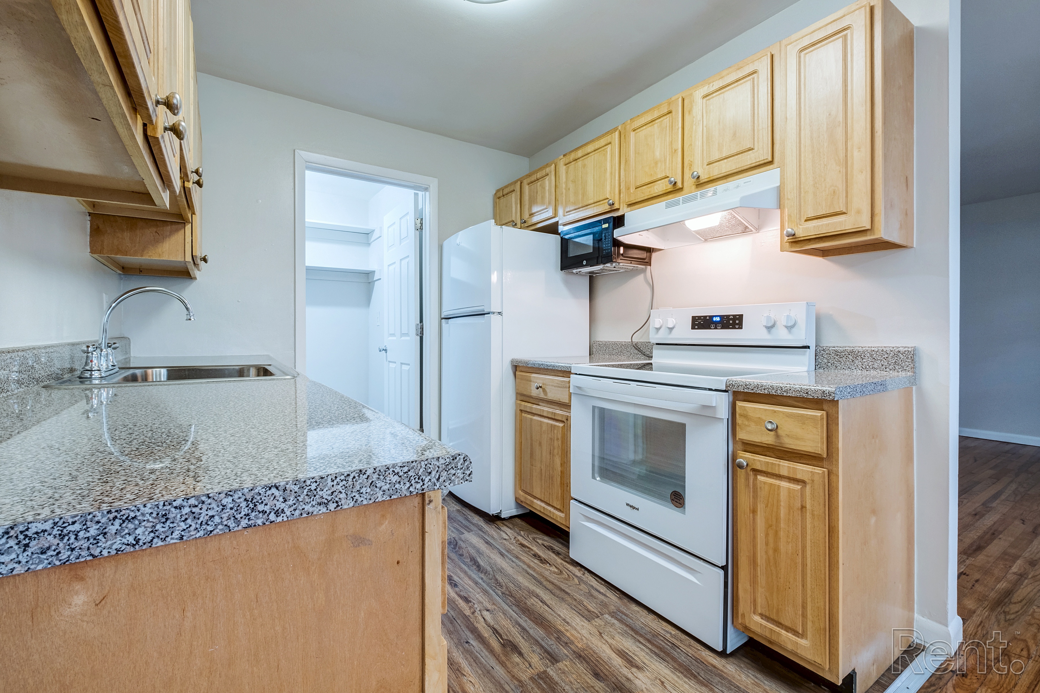 A kitchen with wooden cabinets and white appliances.