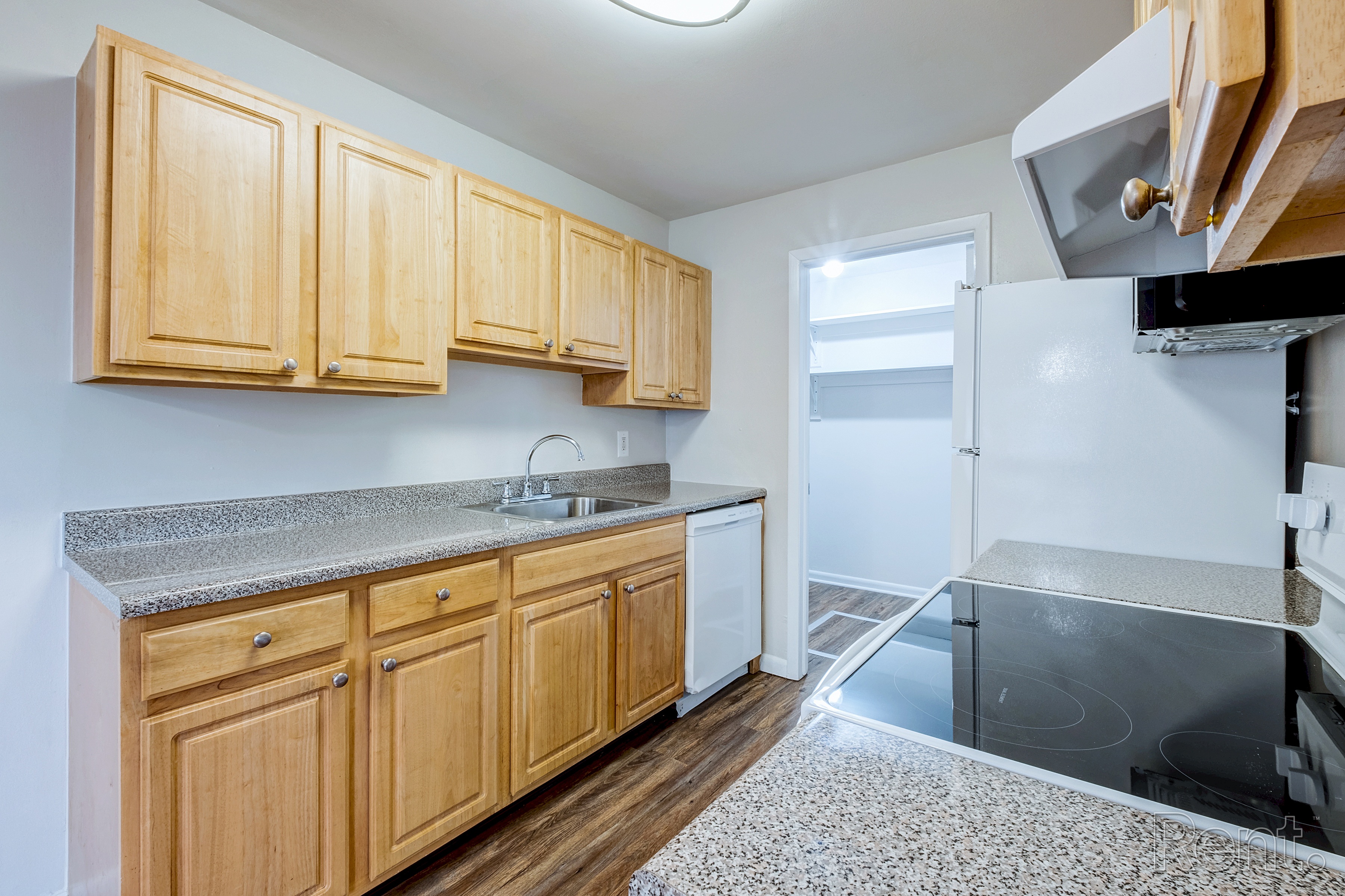 A kitchen with wooden cabinets and a granite countertop.
