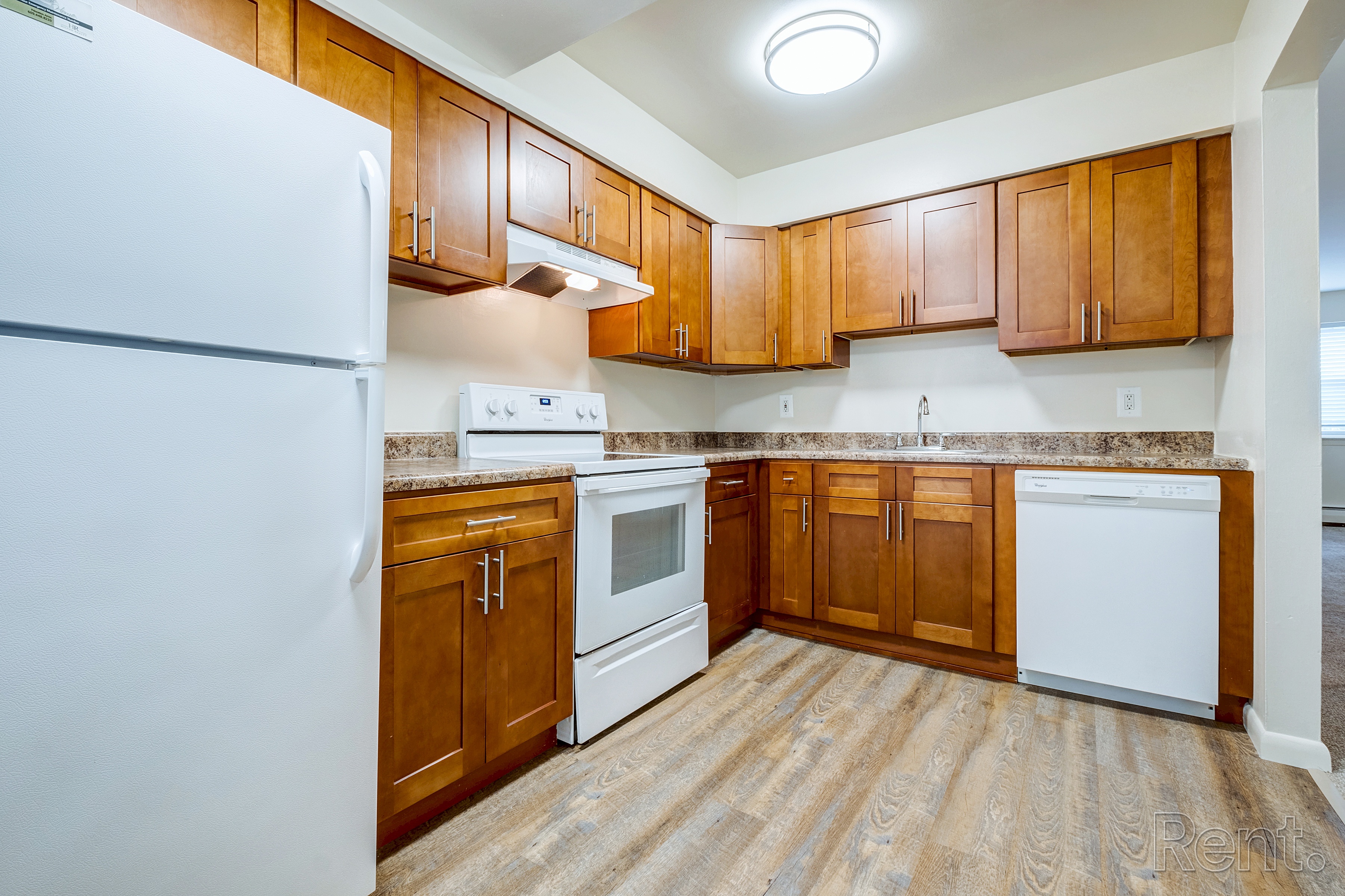 A kitchen with wooden cabinets and a white refrigerator.
