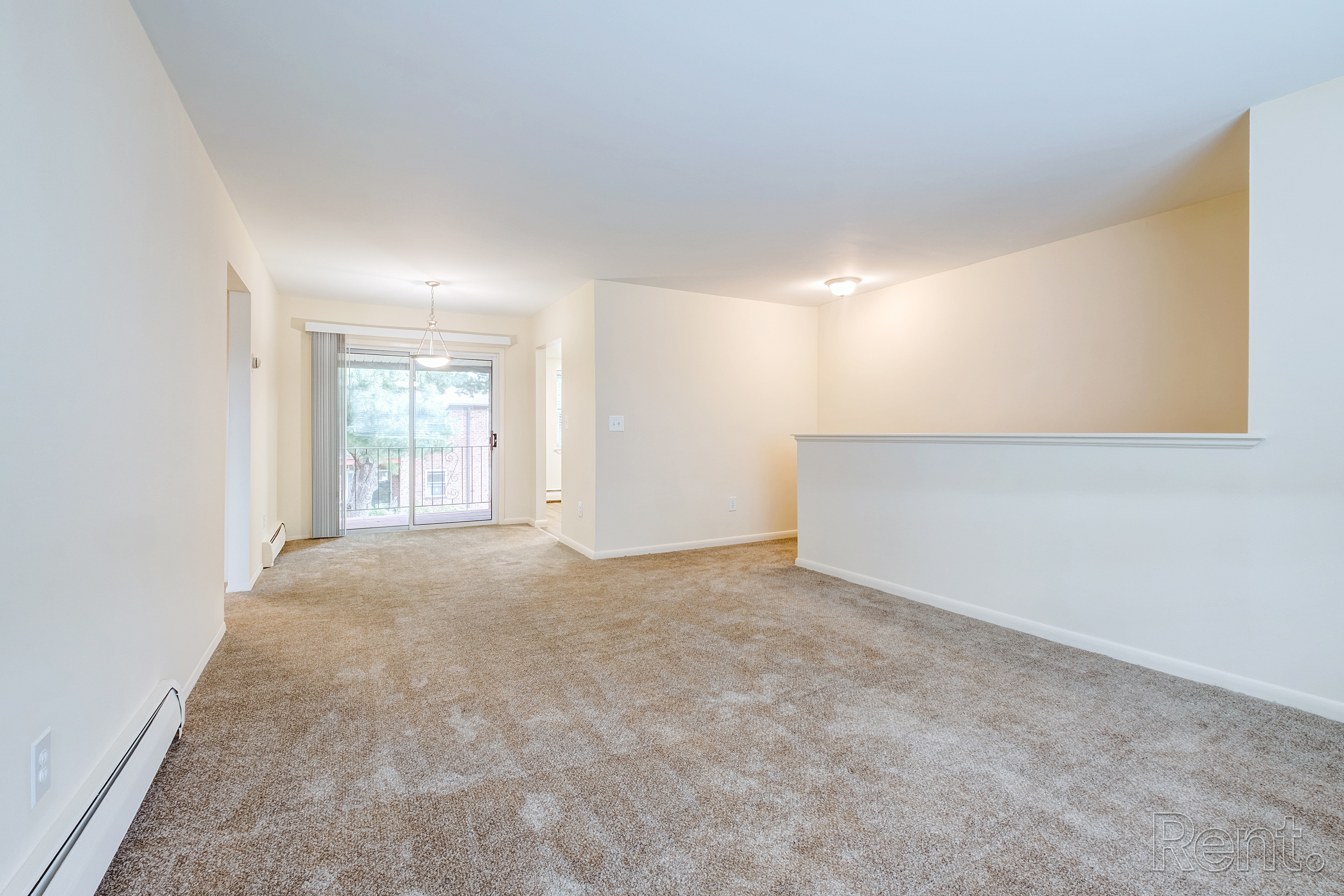 A spacious room with carpeted floor and white walls.
