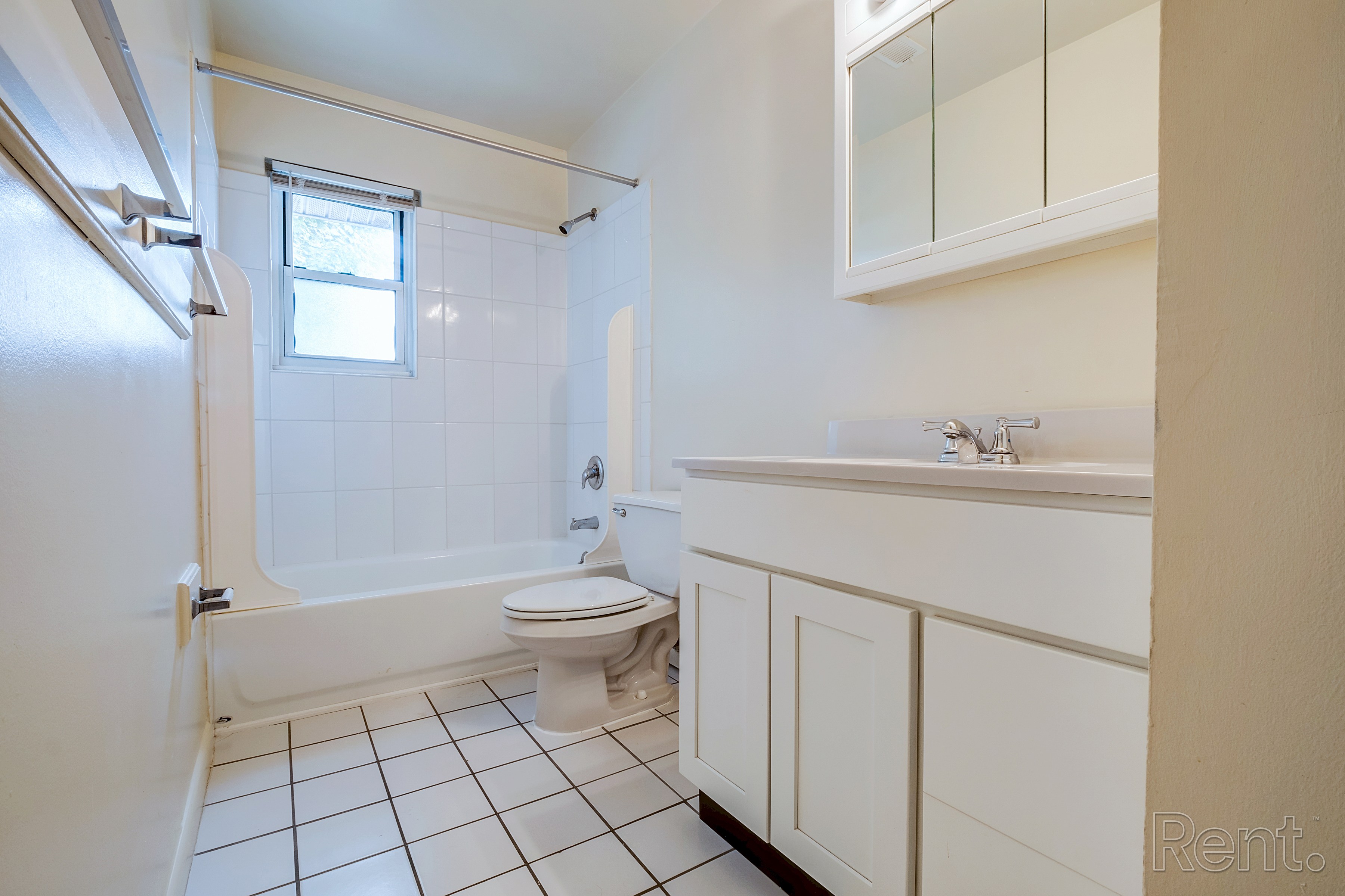 A white bathroom with a toilet, sink, and shower.