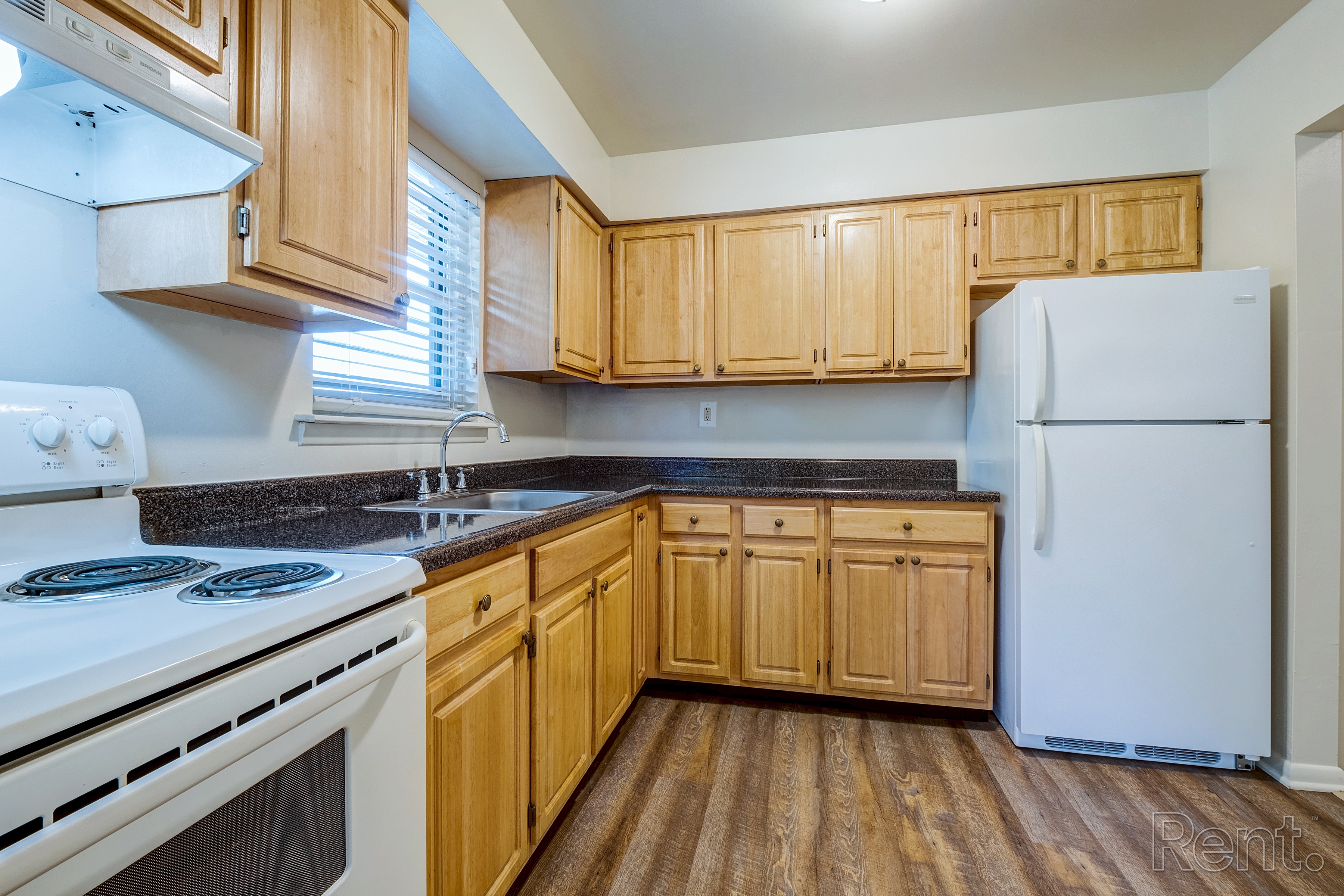 A kitchen with wooden cabinets and a white refrigerator.