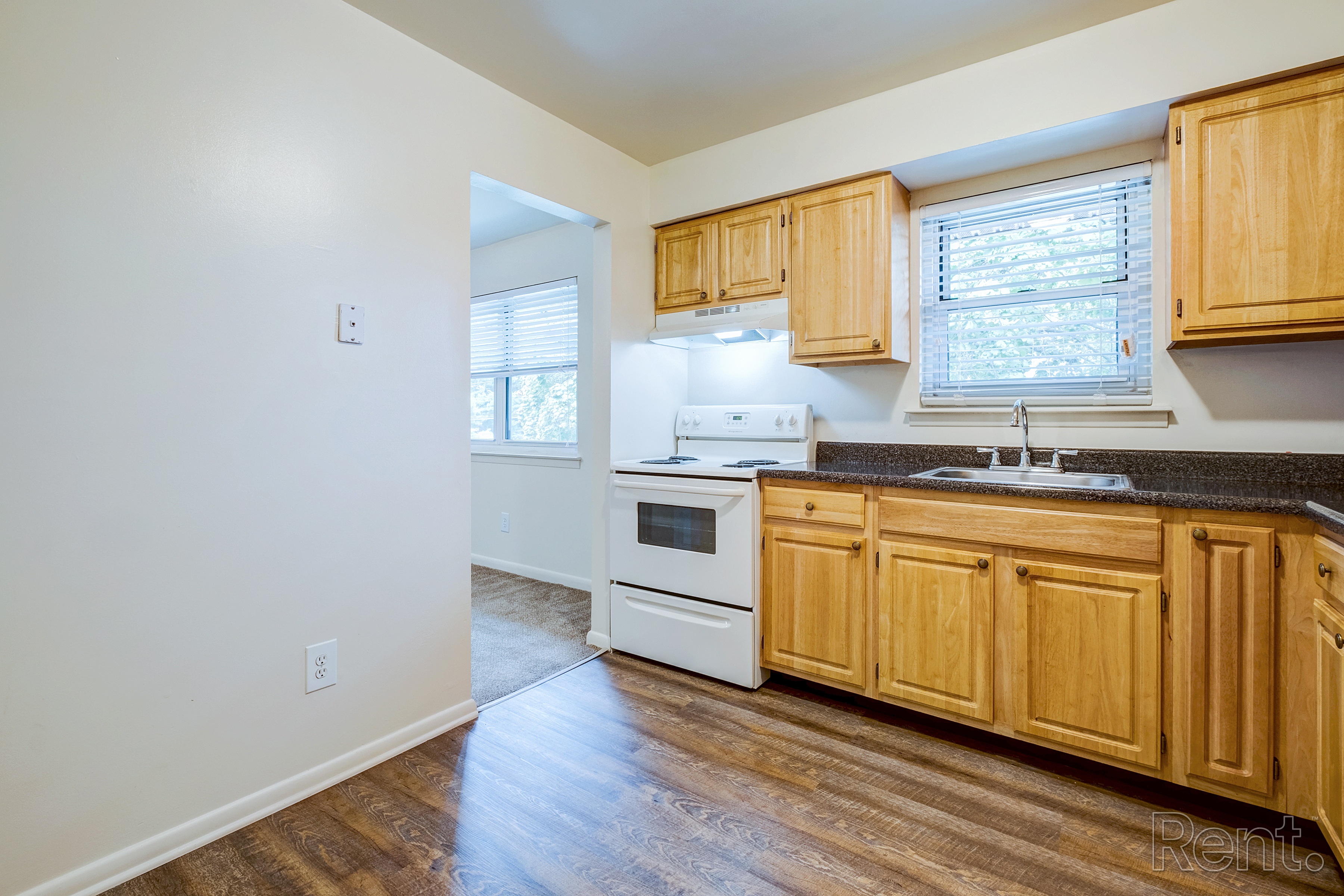 A kitchen with wooden cabinets and white appliances.