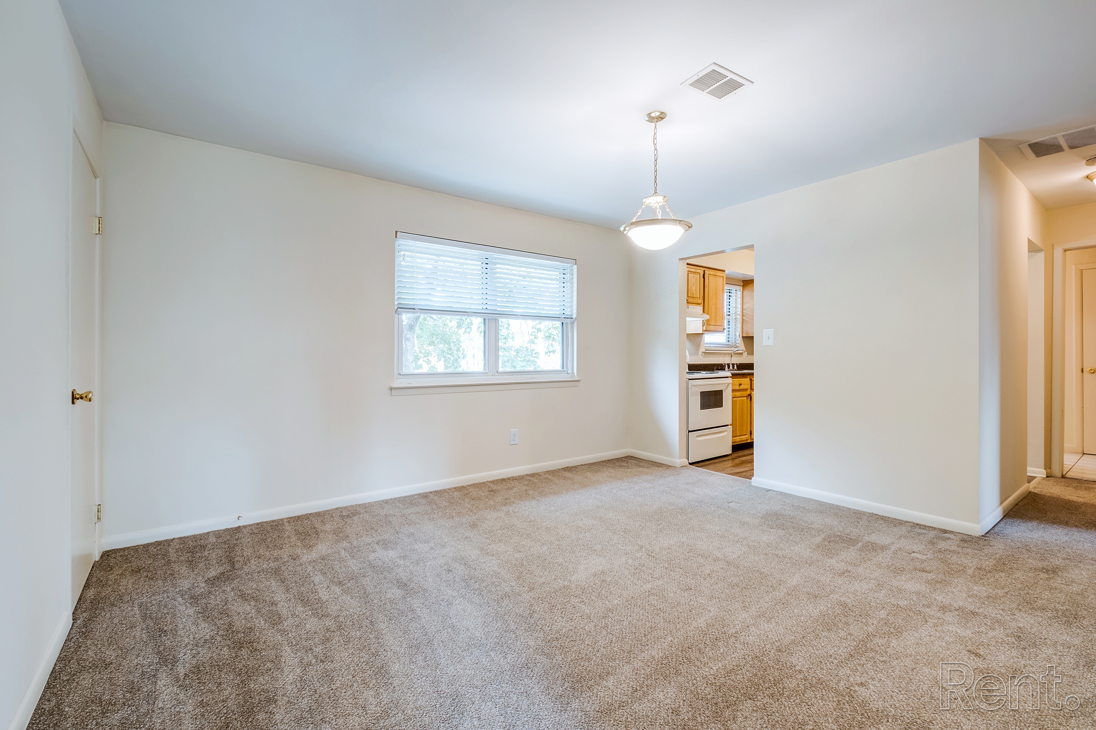 A room with a carpeted floor and a window.