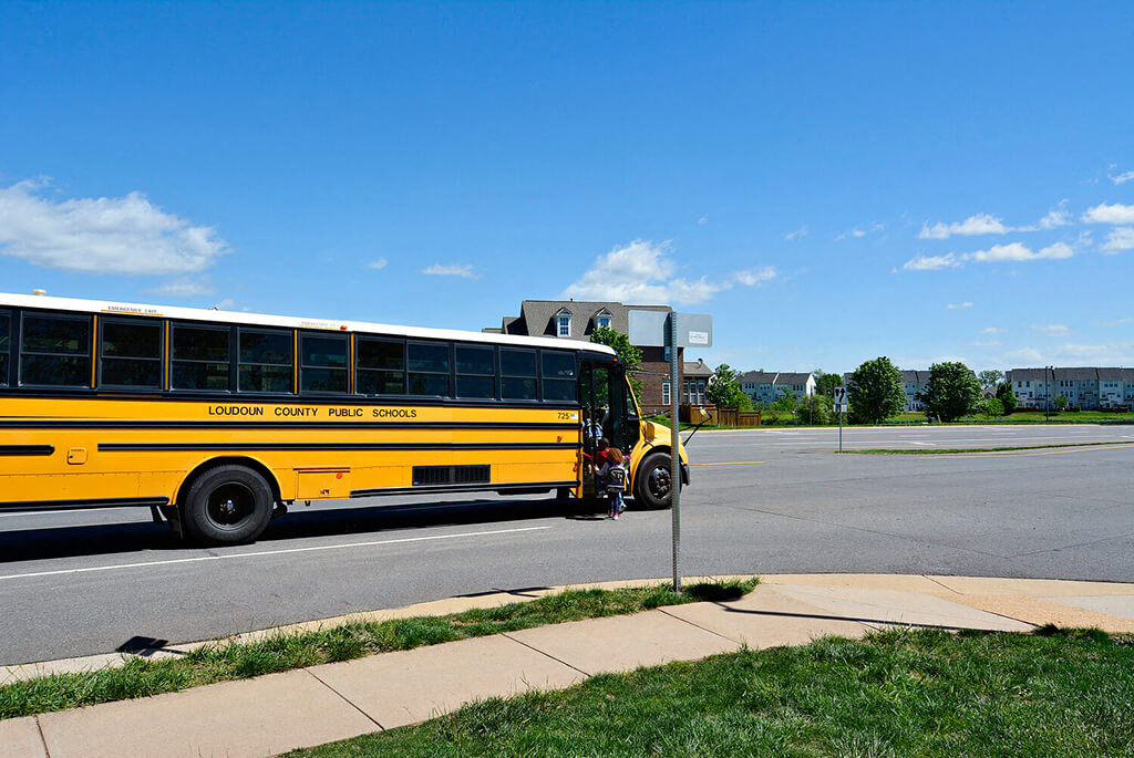 A yellow school bus is parked on the side of the road.