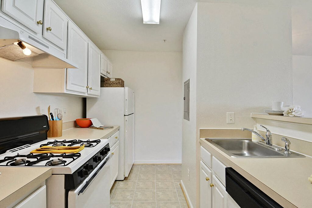 A kitchen with a black stove top oven and white cabinets.