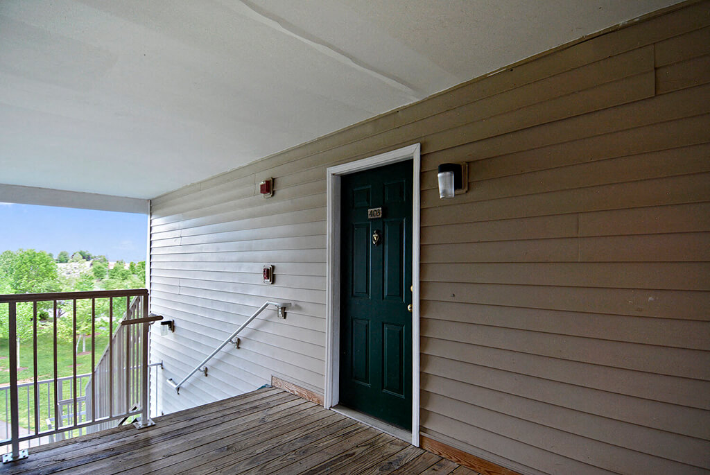 A green door is on the side of a house.