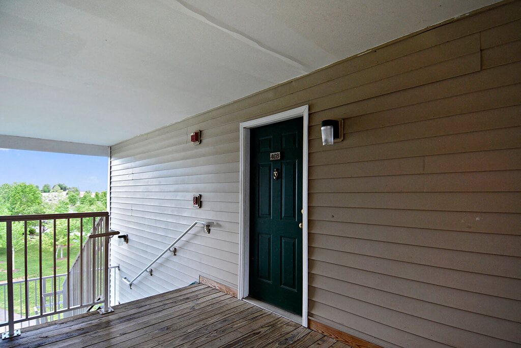 A green door is on the side of a house.