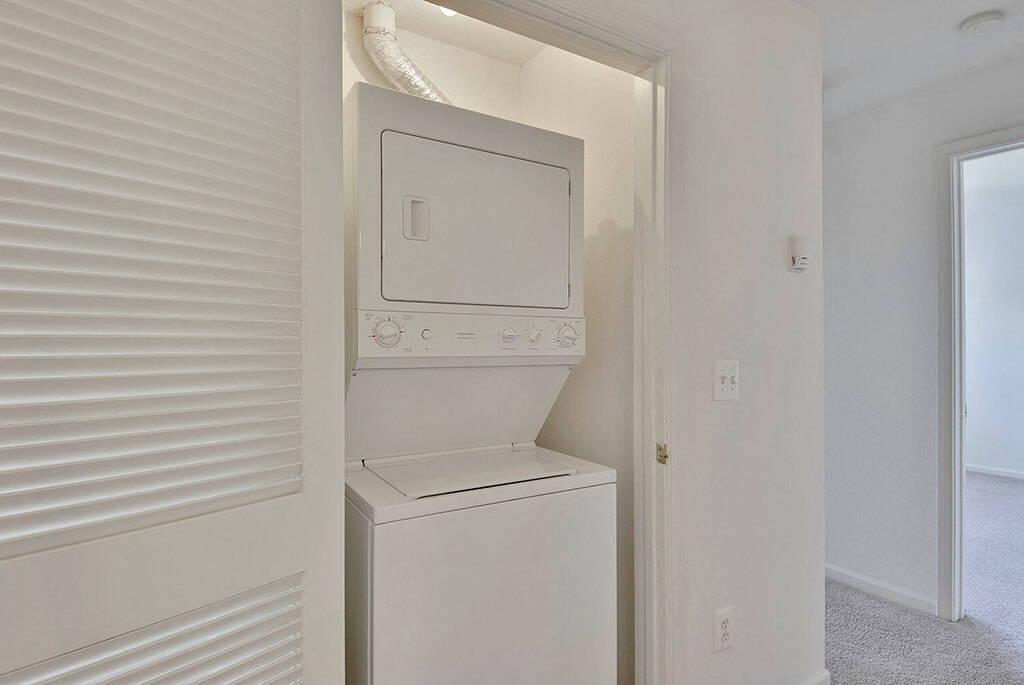 A white washing machine is built into a wall.