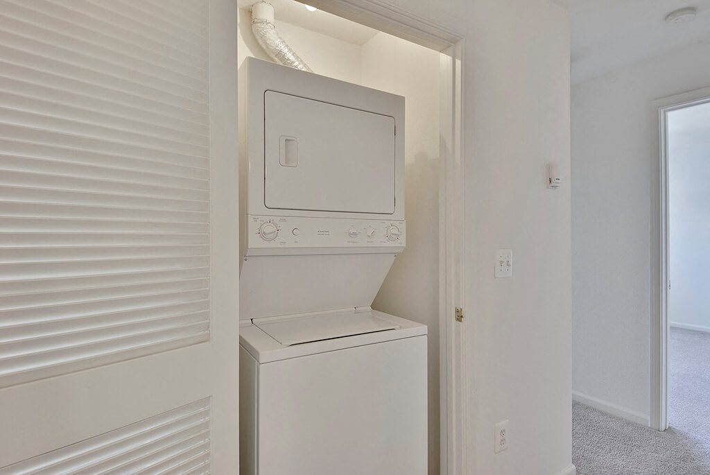 A white washing machine is built into a wall.