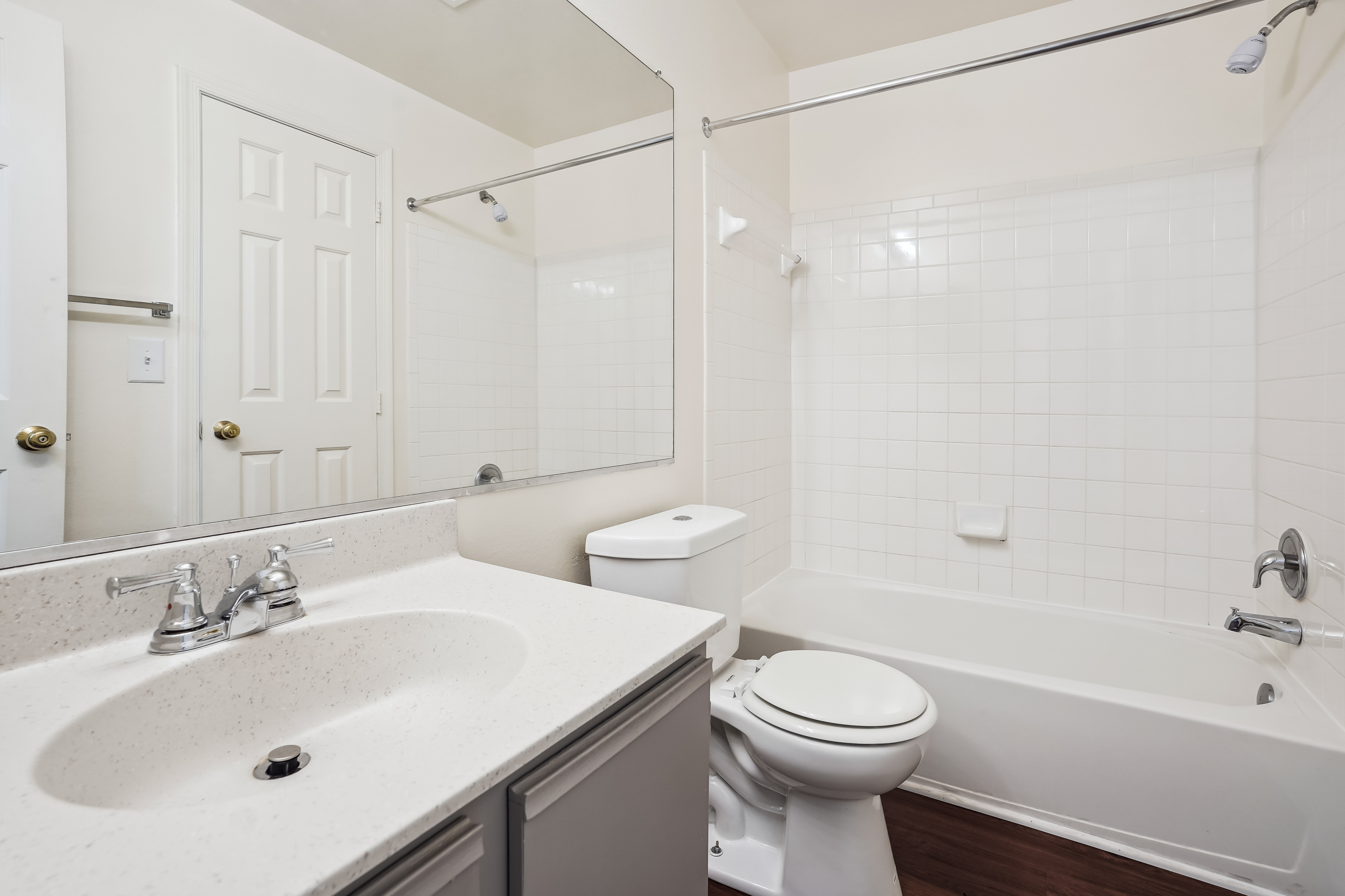A white bathroom with a toilet, sink, and bathtub.