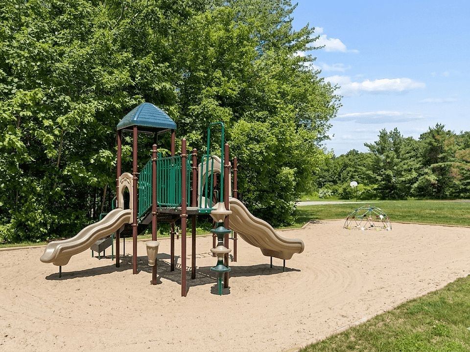 A playground with a green slide and a brown slide.
