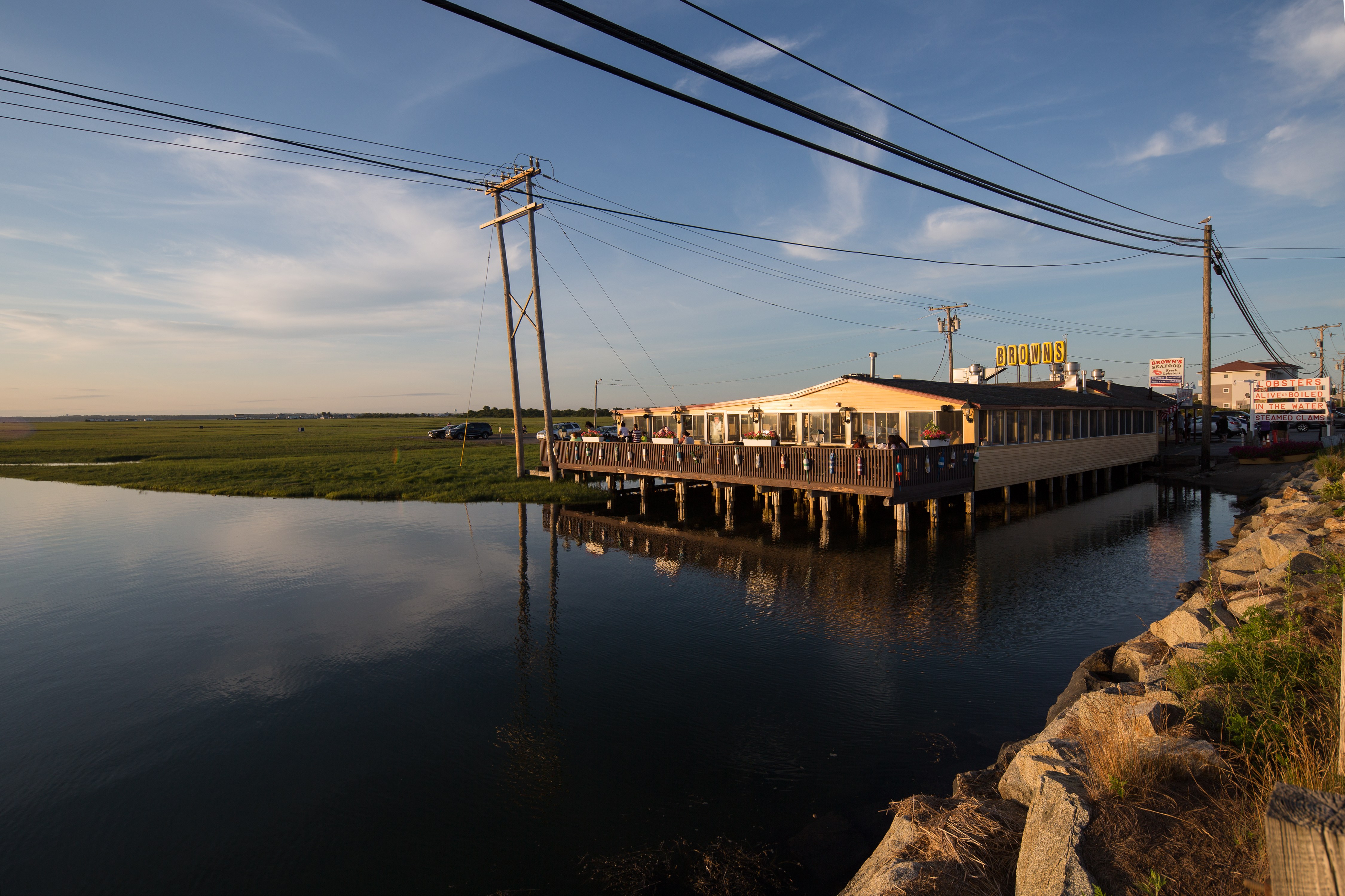A long pier extends into a body of water with a building on it.