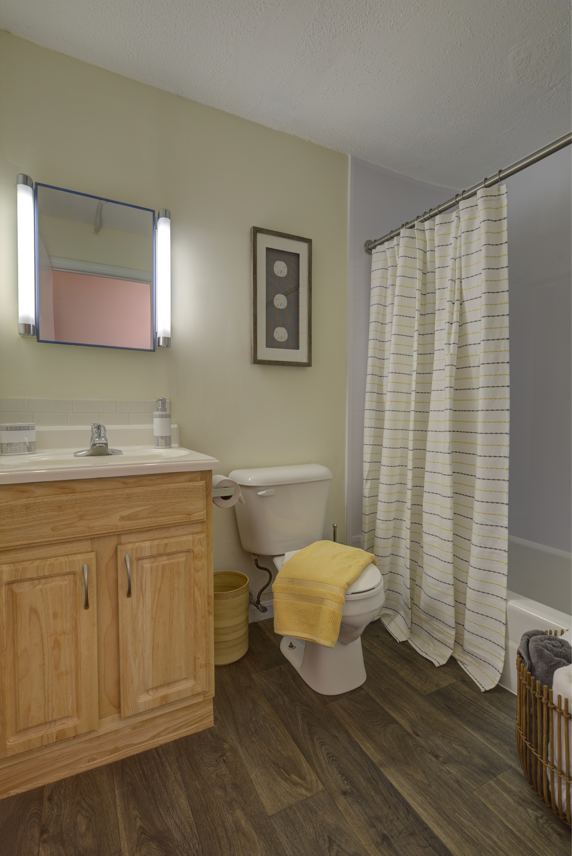 A bathroom with a wooden vanity and a white toilet.