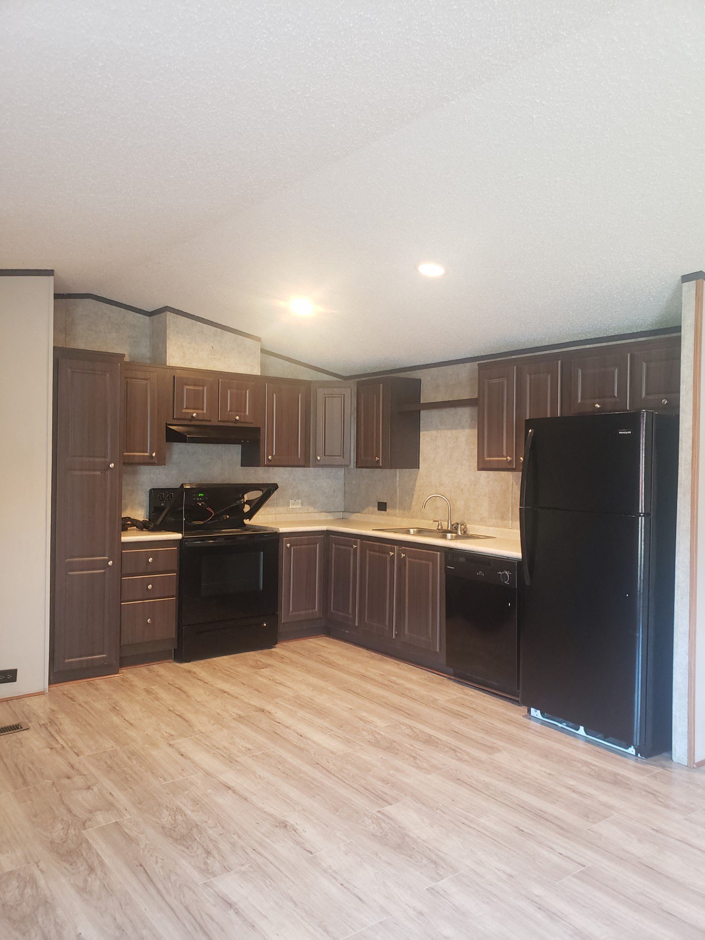 a kitchen with dark cabinets and a wooden floor