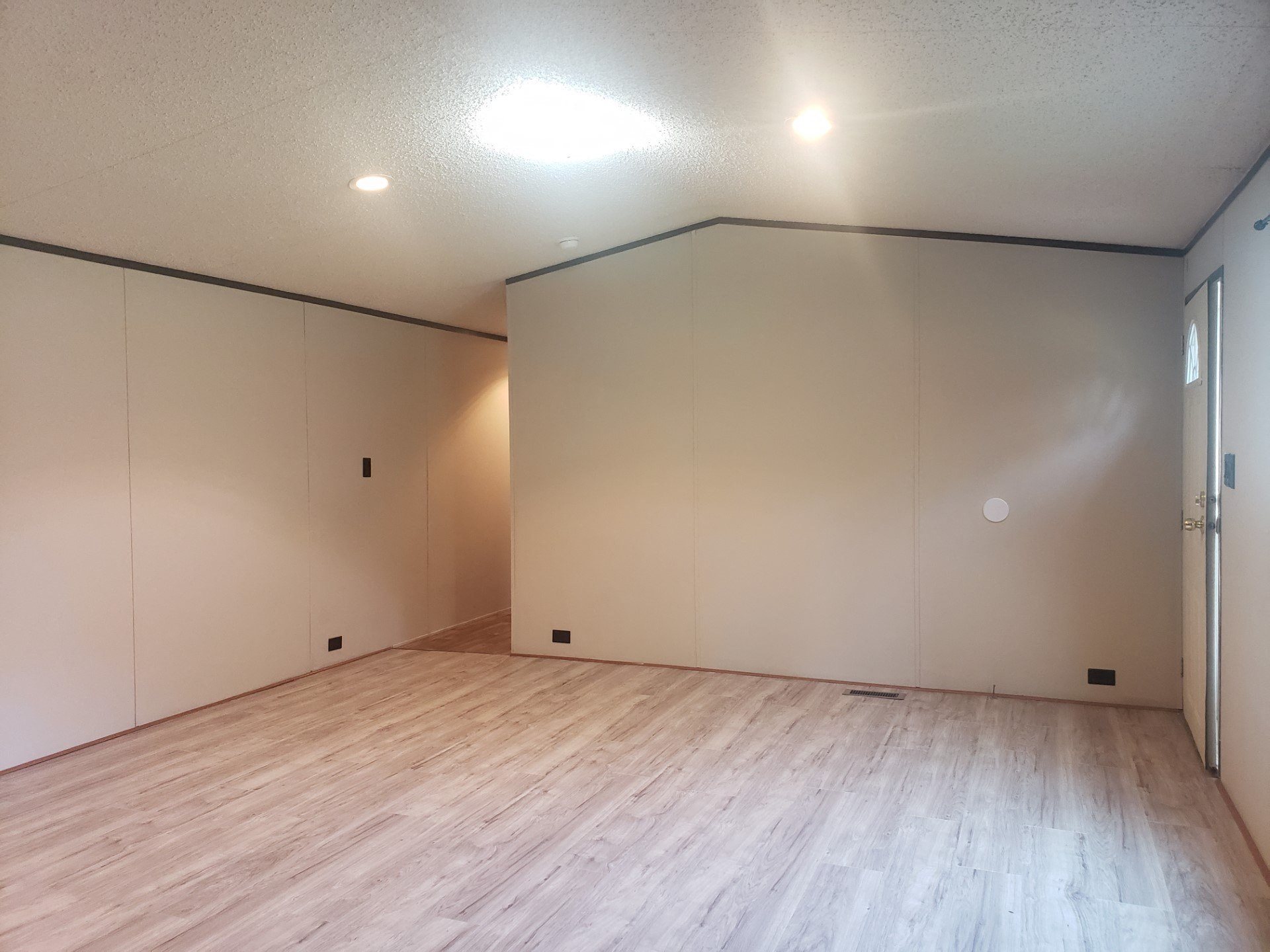 an empty room with white walls and a wooden floor