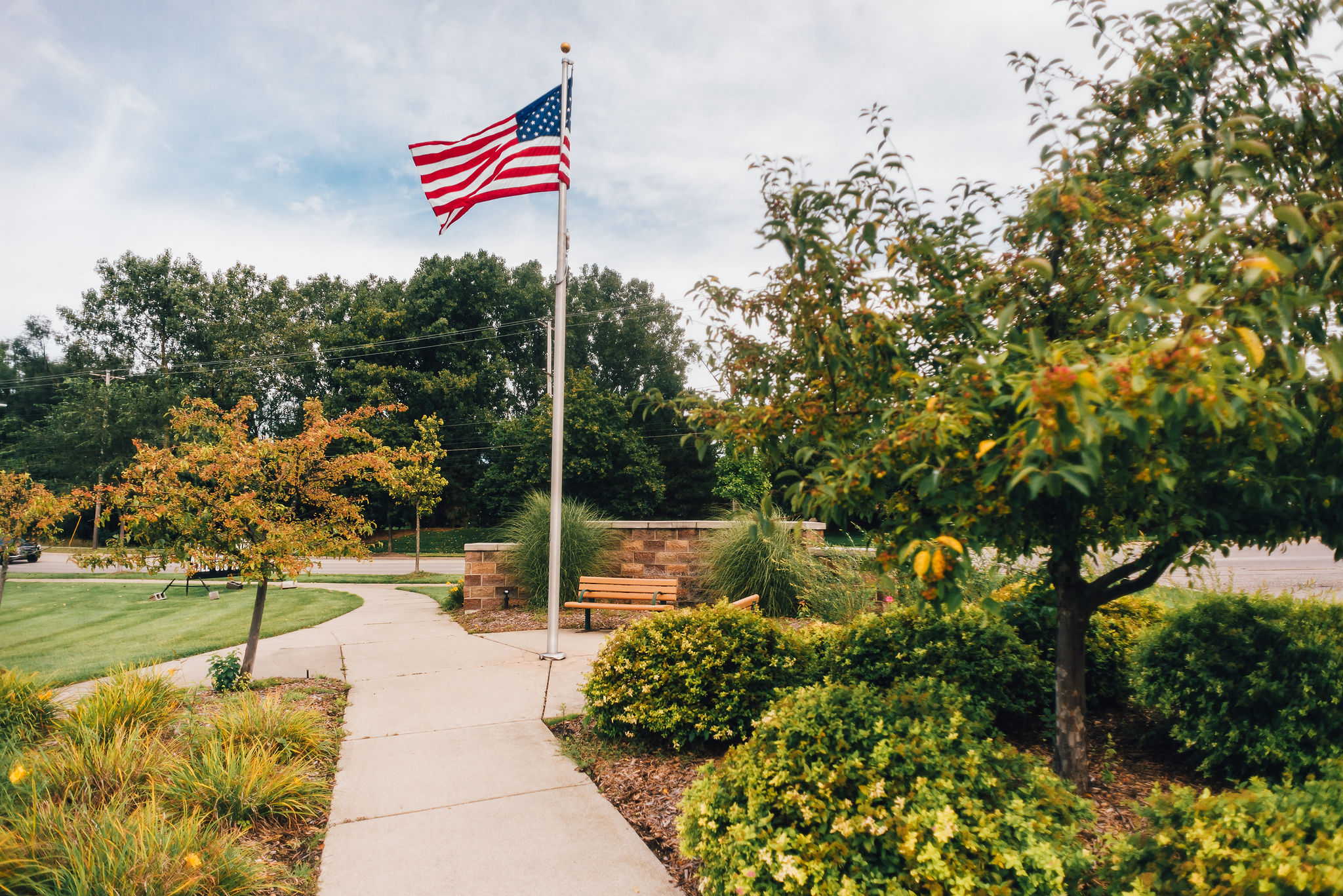 American flag with landscaping and sidewalk