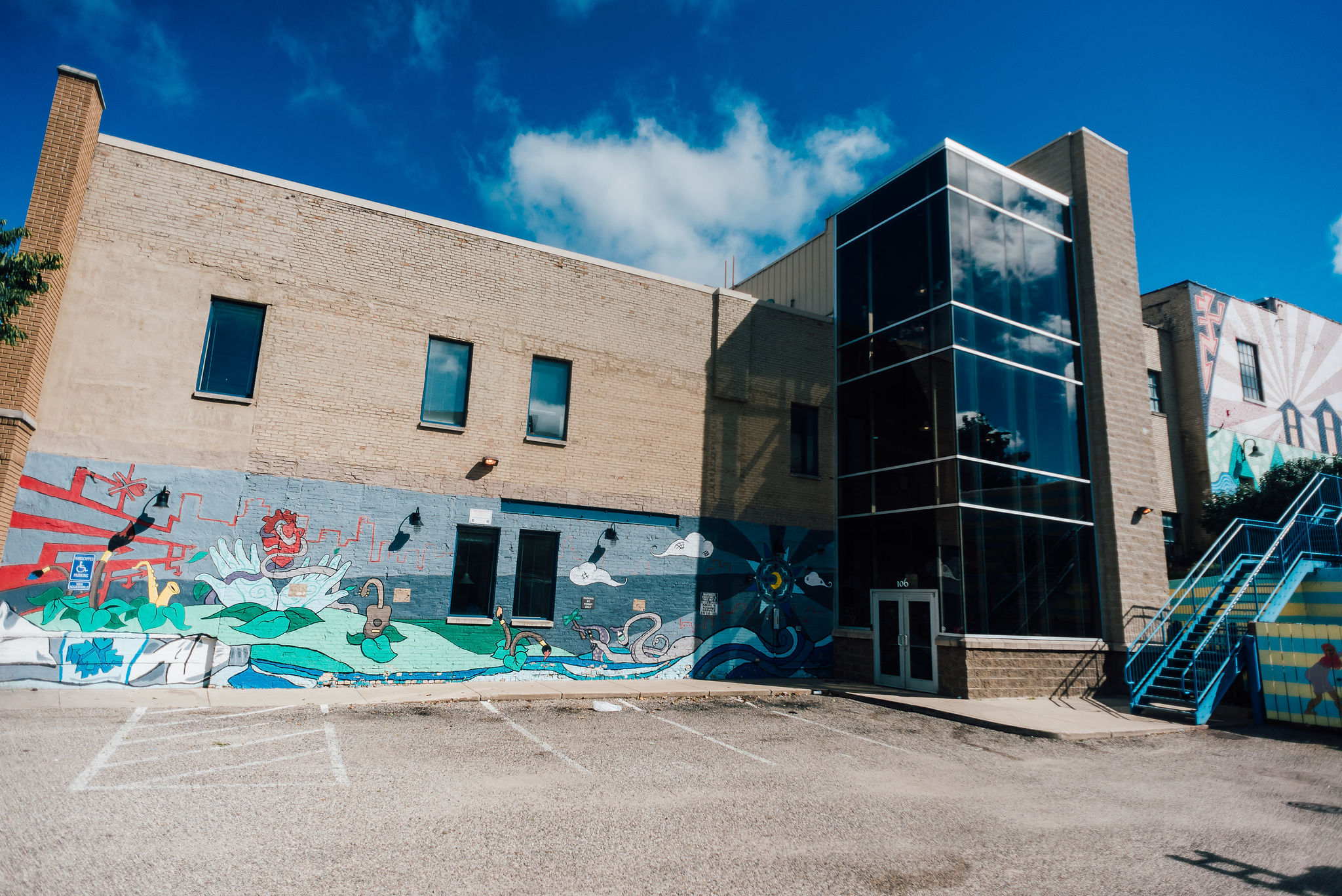 exterior of historic apartment building with mural and glass entry