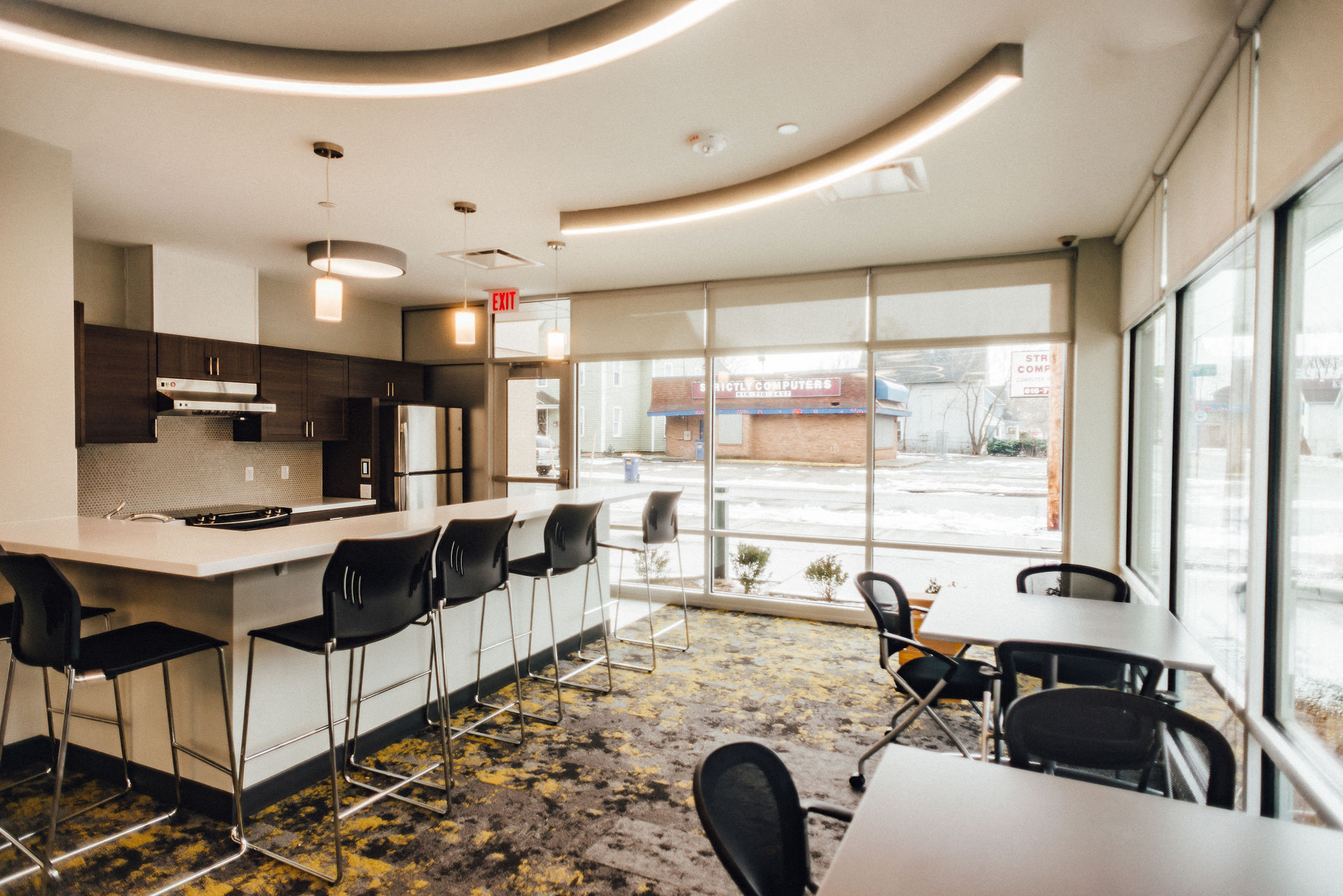 community room with bar seating modern light fixtures