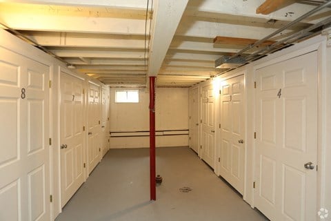 a large room with many white doors and a red pole