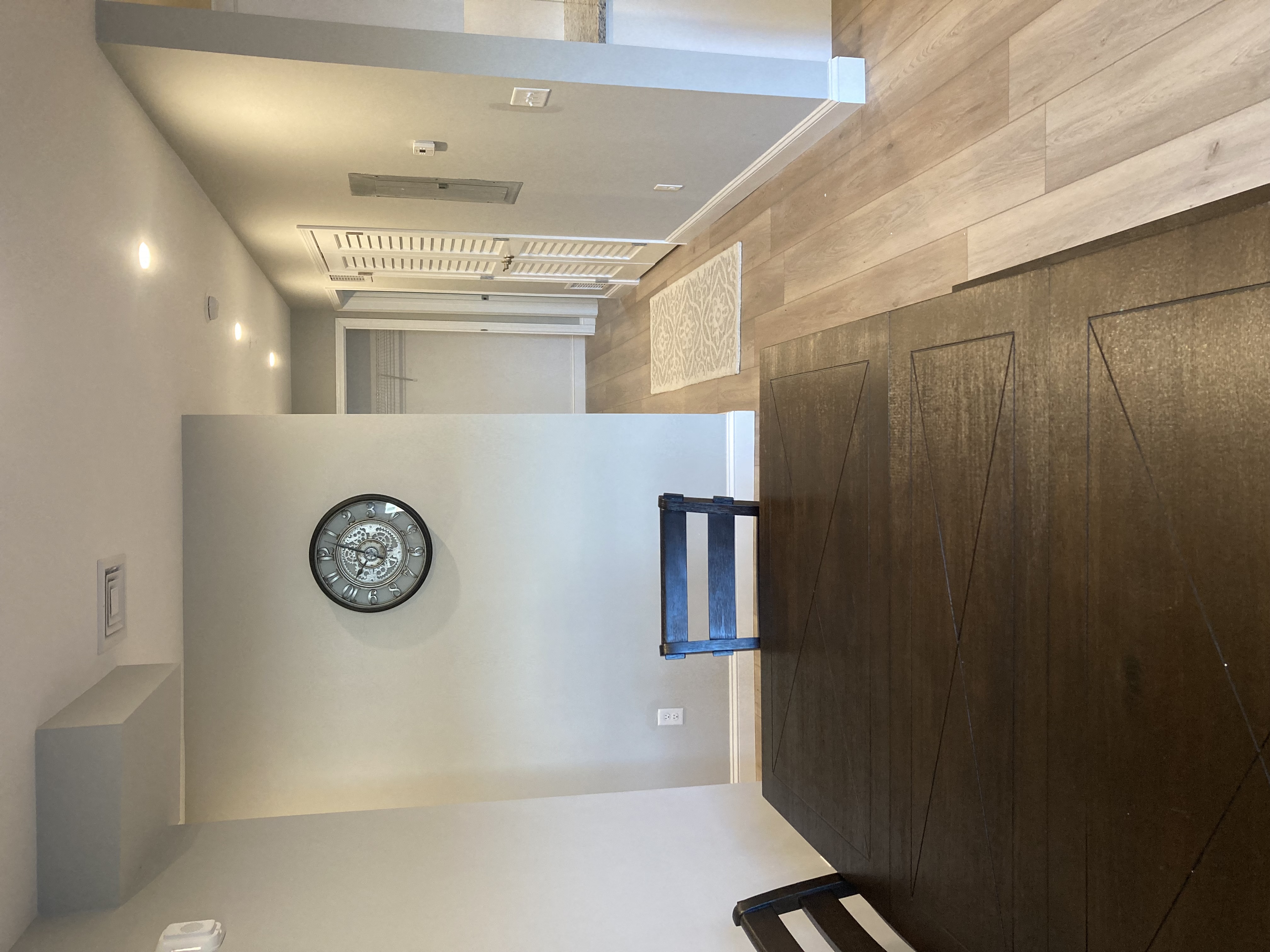 a hallway with a clock on the wall and a wooden door