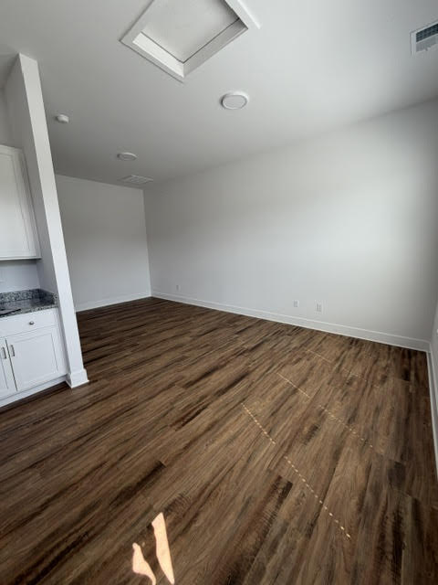 A room with wooden flooring and a skylight.