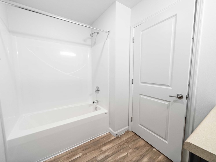 a bathroom with a white bathtub and a white door  at Union at Wiley, Cedar Rapids, Iowa