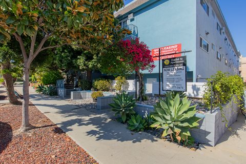 a sidewalk in front of a building with a sign on it