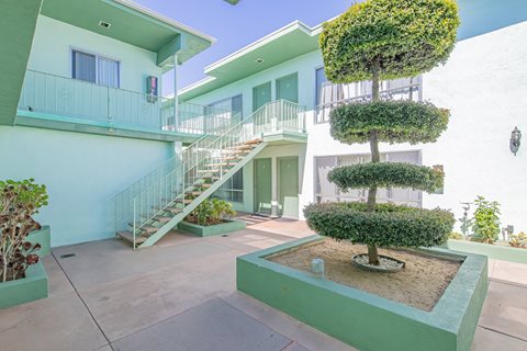 a building with stairs and a courtyard with a tree