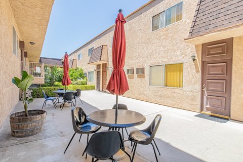 a patio with tables and chairs outside of a building