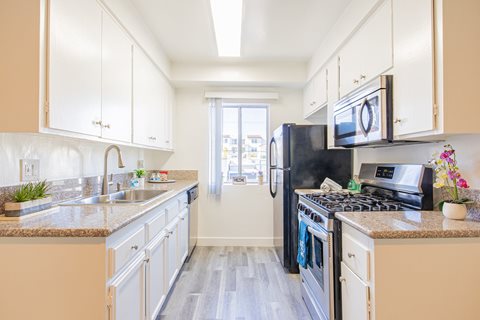 a kitchen with white cabinets and stainless steel appliances and granite counter tops