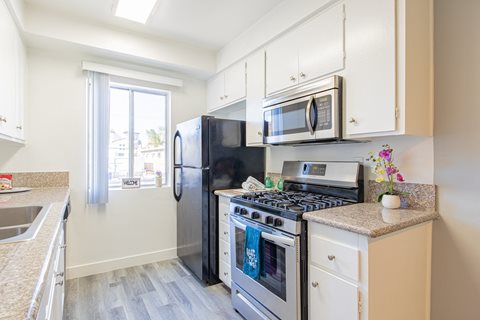 a kitchen with stainless steel appliances and white cabinets