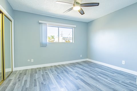 an empty room with a window and a ceiling fan