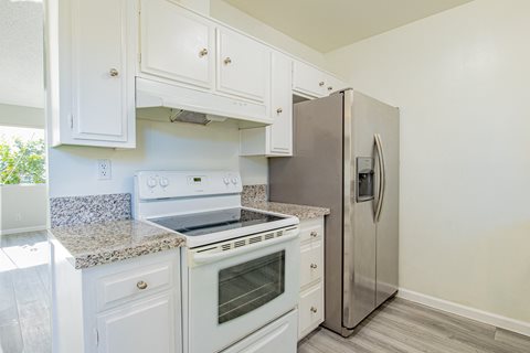 a kitchen with white cabinets and a stainless steel refrigerator