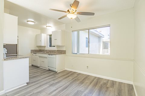 an empty kitchen and living room with a ceiling fan