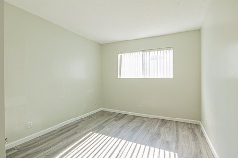 an empty room with wood floors and a window