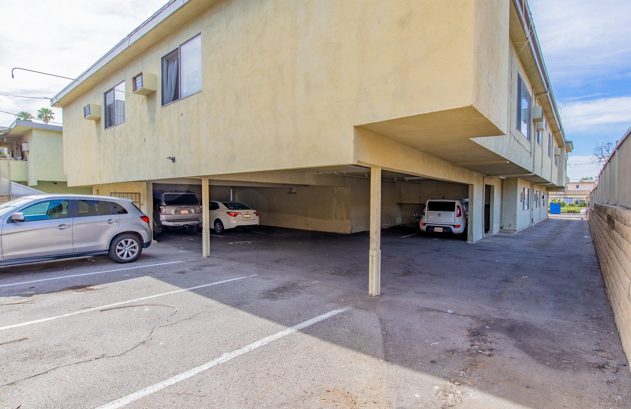 a parking lot with cars parked under a building