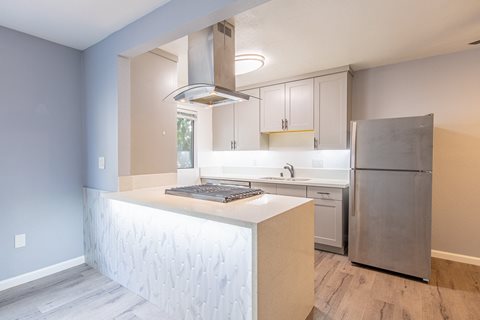 a kitchen with white cabinets and a stainless steel refrigerator