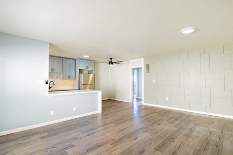 an empty living room with white walls and wood floors