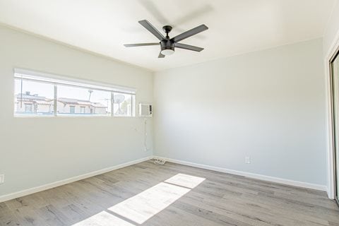 an empty room with a ceiling fan and a window